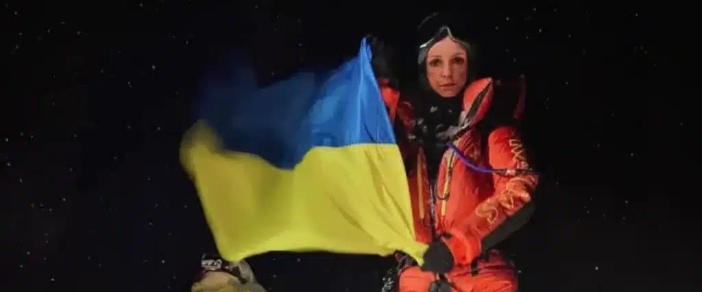 Russian Climber holding Ukranian Flag in Everest.